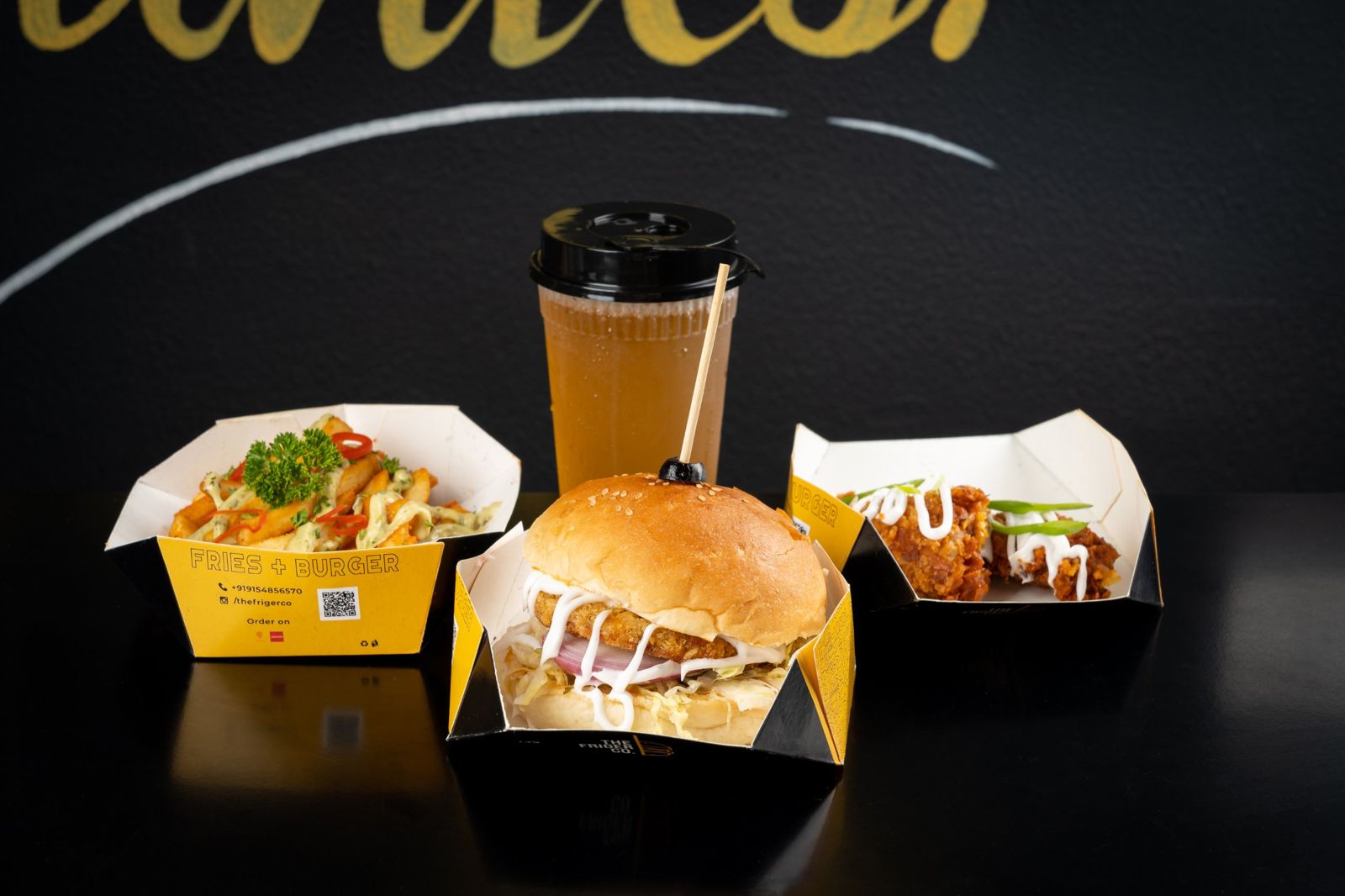 Friger burger, loaded fries, fried chicken and iced tea in Friger boxes