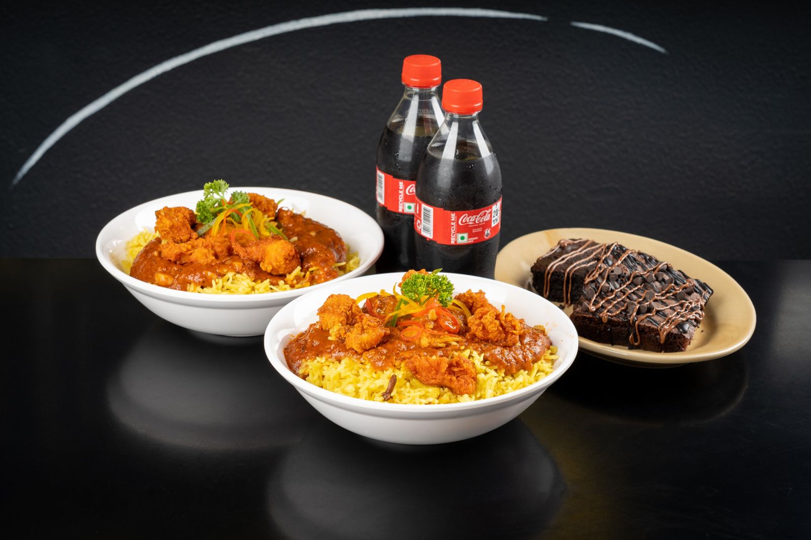 Two chicken rice bowls with drinks and a brownie